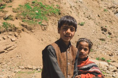 Gilgit Baltistan, Pakistan - 08 Haziran 2018: Dağ yolunda oturan fakir çocuklar