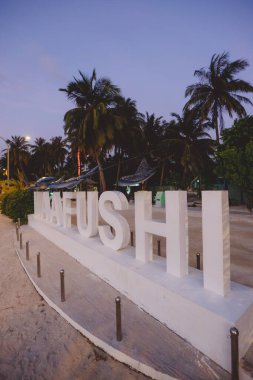 Gün batımında güzel palmiye ağaçları olan Maafushi Adası için Beyaz Taş Mektuplar, Maldivler