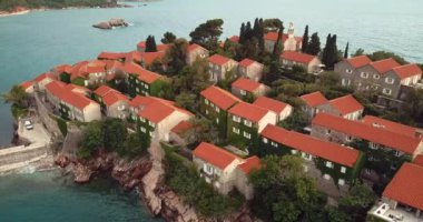 Karadağ 'ın Adriyatik kıyısındaki Saint Stephen (Sveti Stefan) adasına 4K Hava Görüntüsü