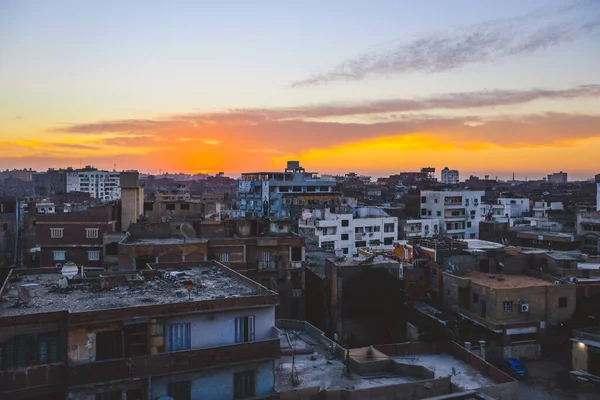 エジプトのカラフルな空と地元の建物があるギザ市への夕日の街の景色 — ストック写真