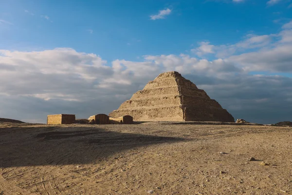 青い空の下でのジョゼールの階段のピラミッドへの壮大な眺めは エジプトのメンフィス市の北西にあるサッカラ ネクロポリスの考古学遺跡です — ストック写真