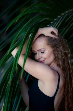 Plajda palmiye ağacı olan bir kız.