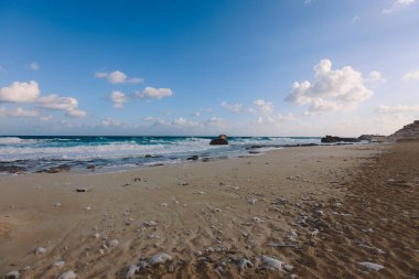 Marsa Matruh şehrinde, Akdeniz 'in rüzgarlı ve kayalık kıyı şeridi. Mavi Bulutlu gökyüzünün altında. Etrafta hiç insan yok.