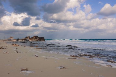 Marsa Matruh şehrinde, Akdeniz 'in rüzgarlı ve kayalık kıyı şeridi. Mavi Bulutlu gökyüzünün altında. Etrafta hiç insan yok.