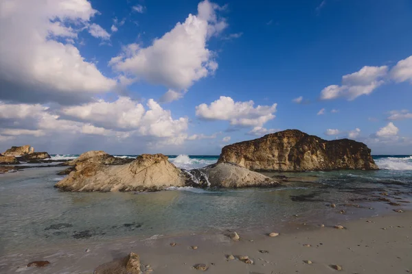 Marsa Matruh şehrinde, Akdeniz 'in rüzgarlı ve kayalık kıyı şeridi. Mavi Bulutlu gökyüzünün altında. Etrafta hiç insan yok.