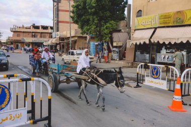 Siwa, Mısır - 03 Kasım 2021: Eski Arabalar, Yerel Halkla ve Batı Çölündeki Büyük Kum Denizi ile Katran Depresyonu arasındaki Siwa Vahasındaki Binalarla Şehir Manzarası