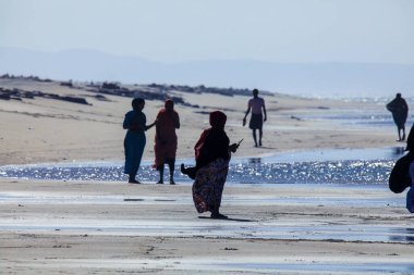 Berbera, Somaliland - 10 Kasım 2019: Berbera yakınlarındaki güneşli bir günde geleneksel siyah elbisesiyle yürüyen yerel halk