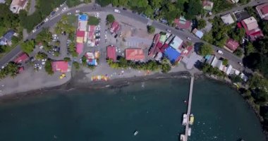 Palmiye ağaçları ve Guadeloupe 'da tatil yapan turistlerle dolu bir sahil.