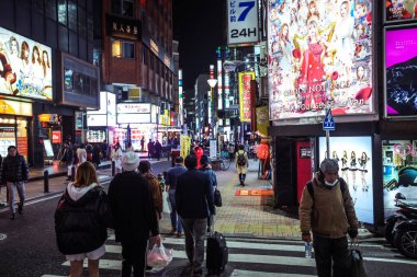 Tokyo, Japonya - 08 Ocak 2020: Turistler ve Yerel Halk, Tokyo sokaklarında gece vakti geçen arabaların arasında yürüyor 