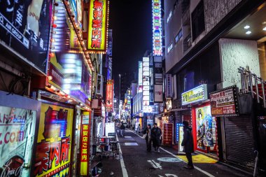 Tokyo, Japonya - 08 Ocak 2020: Turistler ve Yerel Halk, Tokyo sokaklarında gece vakti geçen arabaların arasında yürüyor 