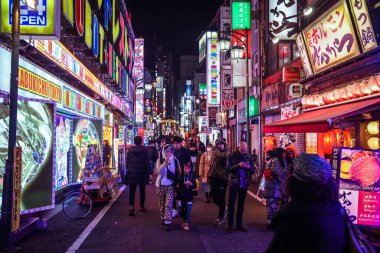 Tokyo, Japonya - 08 Ocak 2020: Turistler ve Yerel Halk, Tokyo sokaklarında gece vakti geçen arabaların arasında yürüyor 