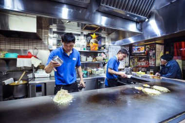 Yerel aşçı Japonya 'daki Hiroşima Restoranı' nda tipik Japon Dişi Okonomiyaki 'yi hazırlıyor.