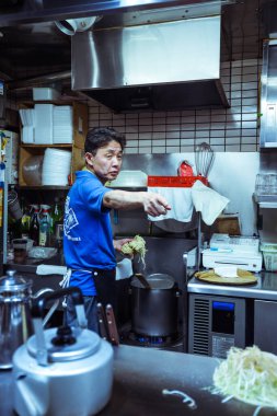 Yerel aşçı Japonya 'daki Hiroşima Restoranı' nda tipik Japon Dişi Okonomiyaki 'yi hazırlıyor.