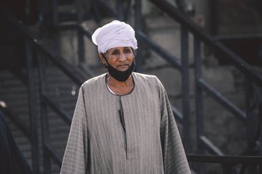 Luxor, Mısır - 12 Kasım 2020: Siyah Arap Elbiseli Yerel Mısırlı Kadın çocuklarıyla birlikte Nil Nehri yakınlarında yürüyor