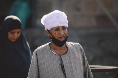 Luxor, Mısır - 12 Kasım 2020: Siyah Arap Elbiseli Yerel Mısırlı Kadın çocuklarıyla birlikte Nil Nehri yakınlarında yürüyor