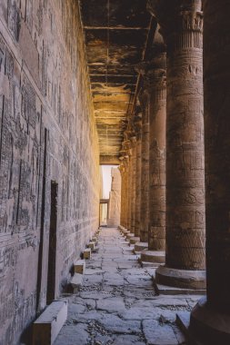 Edfu Tapınağı 'nın iç manzarası. Duvarda oyulmuş sütunlar ve Eski Mısır çizimleri var. 
