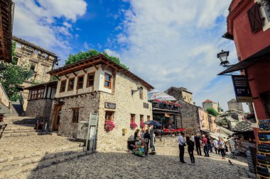 Mostar, Bosnia and Herzegovina - May 12, 2022: Old Town in city center of Mostar with the Colorful Traditional Souvenirs with Walking Tourists clipart