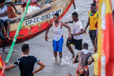 Cape Coast, Gana - 5 Nisan 2022: Yerel Gana Afrikalıları yüzüyor ve sıcak Atlantik Okyanusu 'nda eğleniyorlar