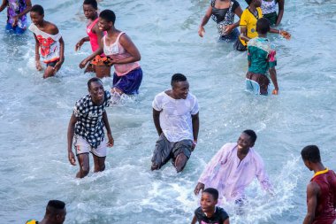 Cape Coast, Gana - 5 Nisan 2022: Yerel Gana Afrikalıları yüzüyor ve sıcak Atlantik Okyanusu 'nda eğleniyorlar