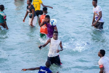 Cape Coast, Gana - 5 Nisan 2022: Yerel Gana Afrikalıları yüzüyor ve sıcak Atlantik Okyanusu 'nda eğleniyorlar