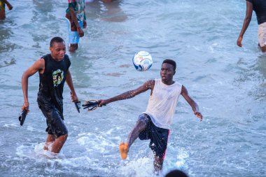 Cape Coast, Gana - 5 Nisan 2022: Yerel Gana Afrikalıları yüzüyor ve sıcak Atlantik Okyanusu 'nda eğleniyorlar