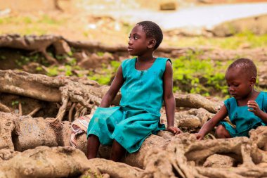 Amedzofe, Ghana - April 2022: African Pupils in Colorful School Uniform near the small Ghana Amedzofe town