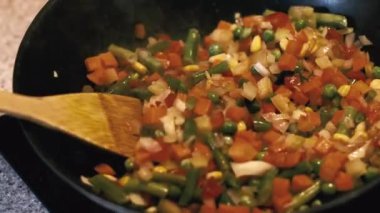 Vegetables are fried in a wok pan