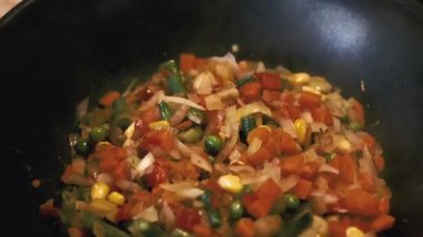 Vegetables are fried in a wok pan