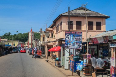 Cape Coast, Ghana - April 14, 2022: Cityscape of Local African Cape Coast town with Ghana People and Cars on the street