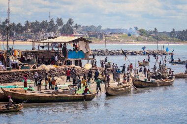 Elmina, Ghana - April 15, 2022: Atlantic Ocean View in the Elmina port with Boats and Local Fishermen in Ghana