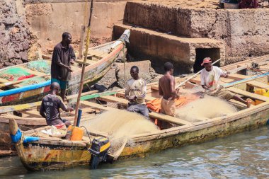 Elmina, Ghana - April 15, 2022: Atlantic Ocean View in the Elmina port with Boats and Local Fishermen in Ghana