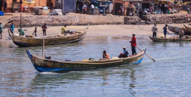 Elmina, Ghana - April 15, 2022: Atlantic Ocean View in the Elmina port with Boats and Local Fishermen in Ghana