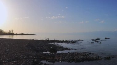 Kırgızistan 'daki Issyk Kul Gölü kıyısında Günbatımı