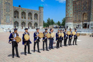 Özbekistan, Semerkant - 12 Mayıs 2022: Geleneksel Özbek kıyafetleriyle tef müzisyenleri Registan Meydanı 'nın Ana Meydanı' nda