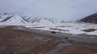 The Road Among Snowy Mountains And A Passing Car, Aerial View