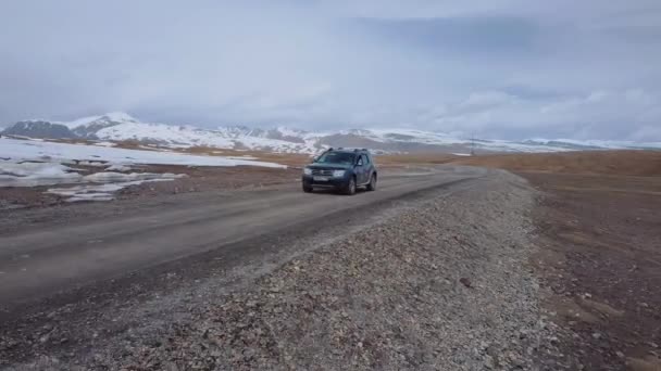 雪山の間の道路と通過車 空中ビュー — ストック動画