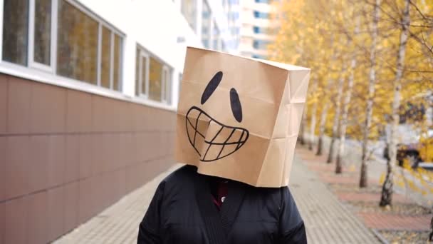 Happy laughing joyful paper bag face walking along street. — Stock Video