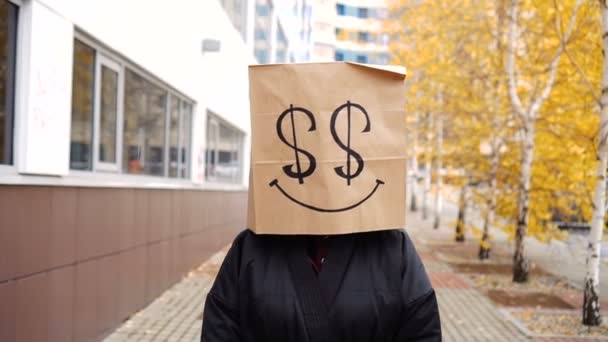 กระเป๋ากระดาษที่อุดมไปด้วยใบหน้าที่เดินไปตามถนน ผู้หญิงตลกในถุงขนมปังที่ดอลลาร์จะถูกวาด — วีดีโอสต็อก