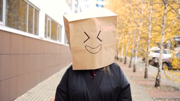 Χαμογελώντας χάρτινη σακούλα πρόσωπο με το στόμα γέλιο περπάτημα κατά μήκος του δρόμου. — Αρχείο Βίντεο