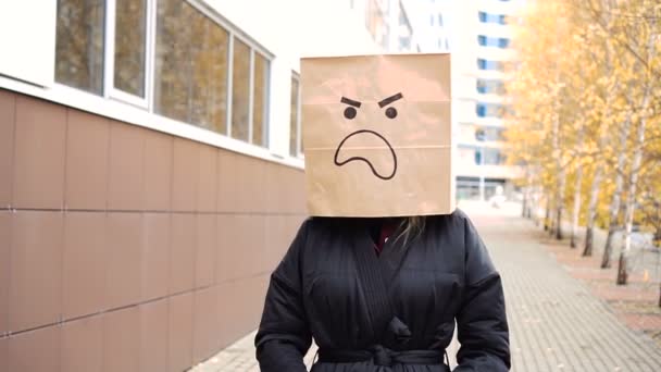 Разгневанное лицо из бумажного пакета с недовольными эмоциями, идущее по улице. — стоковое видео