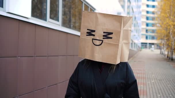 Confuso contente tímido hesitar feliz cara saco de papel andando ao longo da rua — Vídeo de Stock