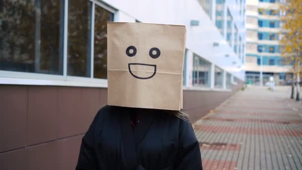 Glimlachend vrolijk papieren tasje dat langs straat loopt. Grappige vrouw draagt broodzak met blij gezicht — Stockvideo