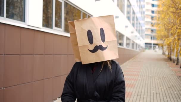 Zadowolona zadowolona papierowa torba twarz z wąsami spacerująca ulicą. — Wideo stockowe