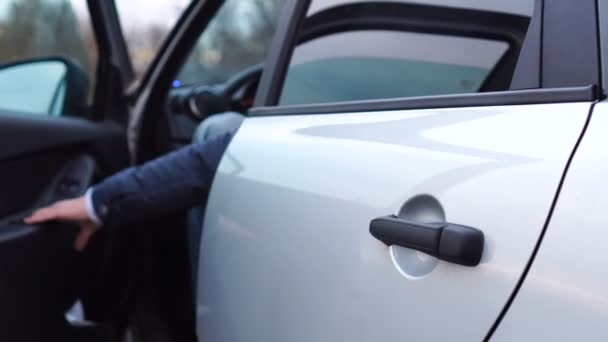 Şoför ya da alıcı sürücü koltuğunun kapısını açar, direksiyonun başına geçer ve kapıyı kapatır, sonra arabadan çıkar ve kapıyı kapatır. — Stok video