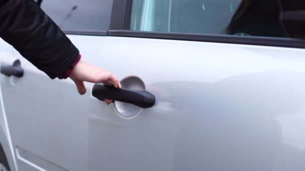 Nierozpoznawalna kobieta wsiada za kierownicę nowego szarego samochodu i zamyka drzwi — Wideo stockowe