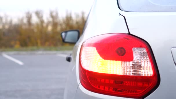 Os sinais de volta amarelos traseiros ou a luz de freio de um carro cinza estão piscando de perto. — Vídeo de Stock