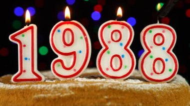 1988 'de yanan beyaz mumlarla birlikte doğum günü pastası.