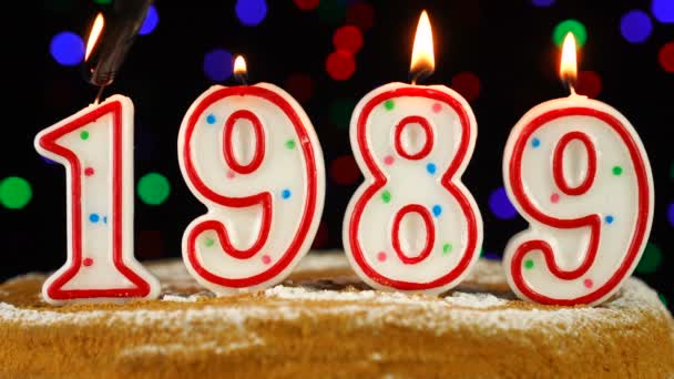 Torta di compleanno con candele che bruciano bianche nella forma del numero 1989 — Video Stock