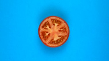 Mavi üzerine izole edilmiş taze bir domatesin rotasyonu. 360 derece döndürme