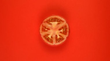 Kırmızı arkaplanda yalıtılmış domates sebzesi, döndür.